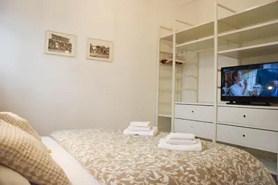 a bedroom with a bed with a television and towels at St. Peter Sweets in Rome