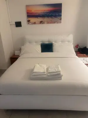 a white bed with two folded towels on it at Munsi guest house in Rome