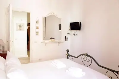 a white bedroom with a bed and a mirror at HC - Richetta's Comfy House near the Vatican in Rome