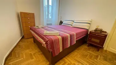 a bedroom with a bed with a striped blanket and a dresser at Da Naya all' Appia Antica in Rome