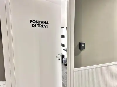 a bathroom with a white door with a sign on it at Xcross Suites Garbatella in Garbatella