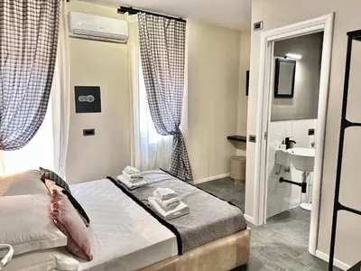 a small bedroom with a bed and a sink at Xcross Suites Garbatella in Garbatella