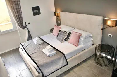 a bedroom with a bed with pink pillows on it at Xcross Suites Garbatella in Garbatella