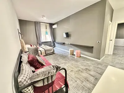 a living room with a couch and two beds at Xcross Suites Garbatella in Garbatella