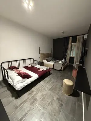 a bedroom with two beds and a stool in it at Xcross Suites Garbatella in Garbatella