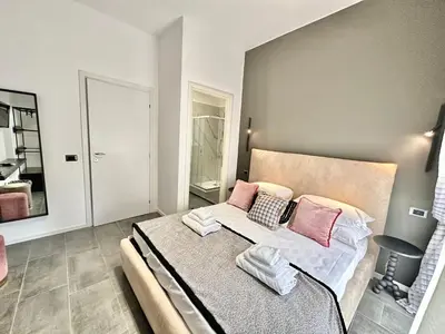 a bedroom with a large bed with pink pillows at Xcross Suites Garbatella in Garbatella