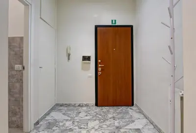 a brown door in a hallway with a tile floor at Vatican's Apartment in Rome