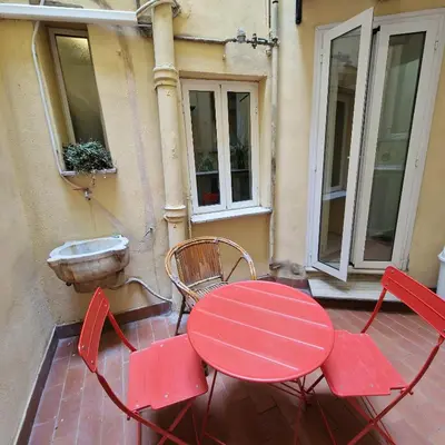 a red table and chairs sitting on a patio at vacanze romane in Rome