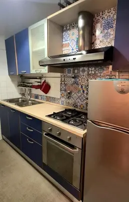 a kitchen with a stainless steel stove and blue cabinets at vacanze romane in Rome