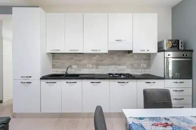 a kitchen with white cabinets and a sink at Silver Dream Cornelia, Elegant Apt with Car Park in Rome