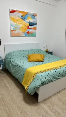 a bed in a bedroom with a painting on the wall at Monti Tiburtini Roma Guest House in Rome