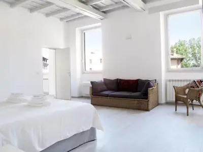 a white living room with a couch and a bed at Spacious, Modern, Bright Apartment, near Piazza Navona! in Rome