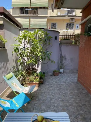 a patio with two chairs and plants and a building at Appartamento luminoso con giardino in Rome