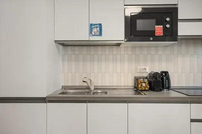 a kitchen with a sink and a microwave at Urban Loft - San Giovanni by RHR in Rome