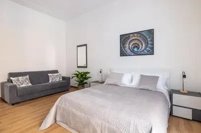 a white bedroom with a bed and a couch at ARGILLA PLACE Large apartment close to Saint Peter Basilica in Rome
