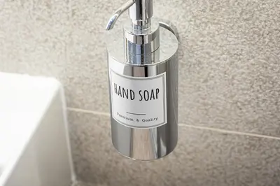 a bottle of hand soap sitting on the side of a wall at ARIOSTO'S Luxury Rooms in Rome