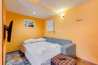 a bedroom with a white bed and orange walls at Casa Garbha in Rome