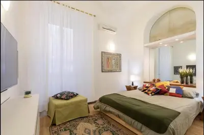 a bedroom with a large bed and a window at Barberini Exclusive Apartment in Rome