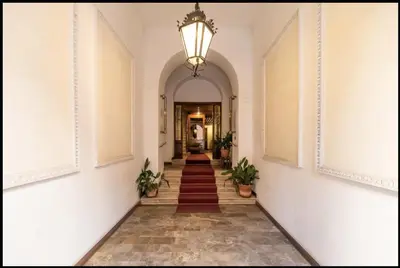 a hallway with an archway and a chandelier at Barberini Exclusive Apartment in Rome