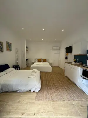 a large room with two beds and a kitchen at Suite San Giovanni in Rome