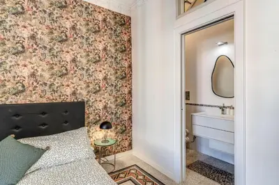 a bedroom with a bed and a sink and a mirror at Emily in Rome in Rome