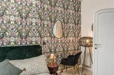 a bedroom with a green bed and a floral wallpaper at Emily in Rome in Rome