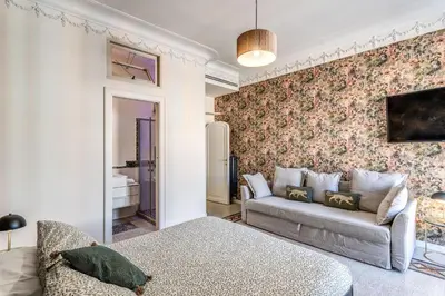 a living room with a couch and floral wallpaper at Emily in Rome in Rome