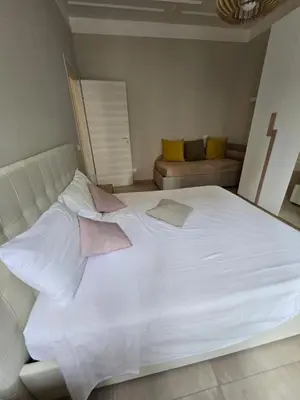 a large white bed in a room with a couch at Biancaapartment in Rome