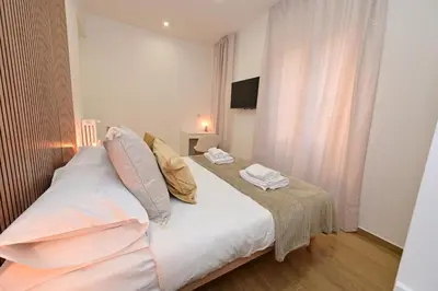 a bedroom with a bed with white sheets and pillows at Relais Trastevere Station in Rome