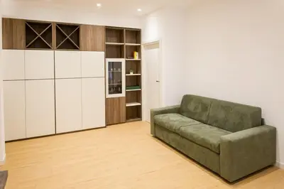 a living room with a green couch and a kitchen at RoomApartment Roma in Rome