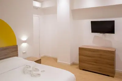 a bedroom with a bed and a tv on a wall at RoomApartment Roma in Rome