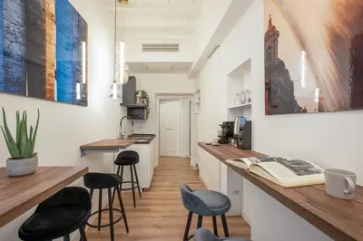 a kitchen with black stools and a counter with a bar at Pantheon Suites Rome 1 in Rome