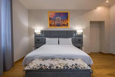 a bedroom with a large bed and a painting on the wall at AP Royal suite guesthouse in Rome