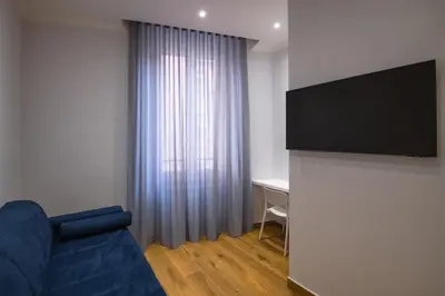 a living room with a blue couch and a television at AP Royal suite guesthouse in Rome