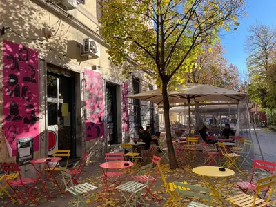an outdoor cafe with tables and chairs and an umbrella at il giardino di frida in Rome
