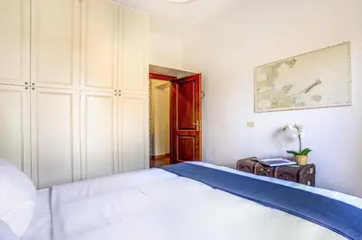 a bedroom with a white bed and a cabinet at Colosseo MecenArt 77 - Home and More in Rome