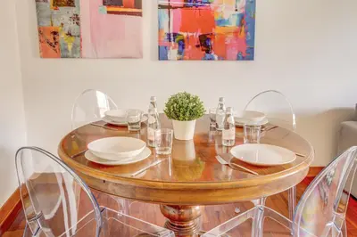 a table with plates and glasses and a plant on it at Colosseo MecenArt 77 - Home and More in Rome