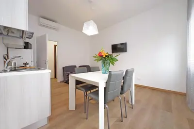 a kitchen and a table with a vase of flowers on it at Trastevere 3 apartments by Flatinrome in Rome