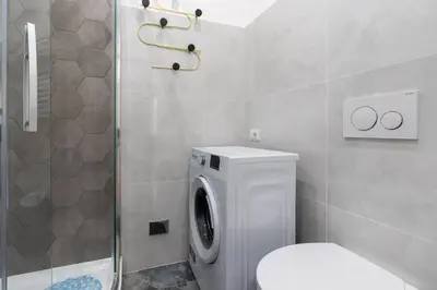 a bathroom with a washing machine and a toilet at Casa Romana Vaticano-Metro in Rome