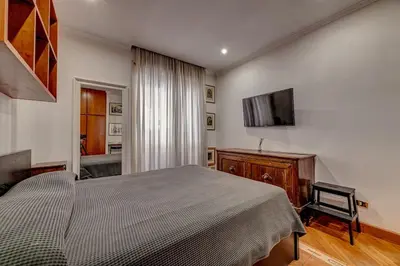 a bedroom with a bed and a flat screen tv at Vatican Luxury Suite Bragadin in Rome