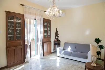a living room with a blue couch and a chandelier at RHome City Garden in Rome