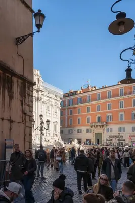 a crowd of people walking down a street at Acque Romane Fontana di Trevi M in Rome