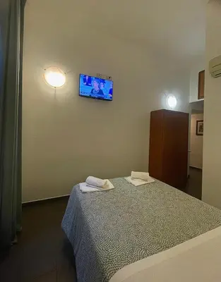 a room with a bed and a tv on the wall at La casa di raffy in Rome