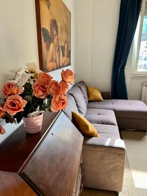 a living room with a couch and a table with flowers at Angelo ai Musei Vaticani bilocale in Rome