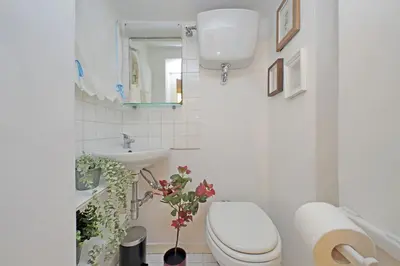 a white bathroom with a toilet and a sink at Cozy Apartment Rione Monti in Rome