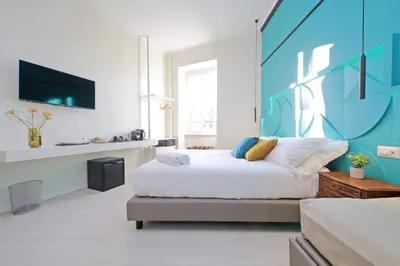 a bedroom with a bed with a blue wall at Domus Augustea - San Giovanni Sunset Suites in Rome