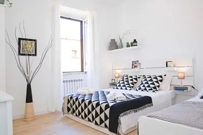 a white bedroom with a bed and a window at Bella Nonna in Rome