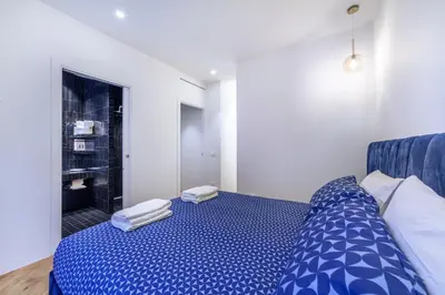 a bedroom with a blue bed with towels on it at Bellina Suite Hi Tech Apartment in Rome