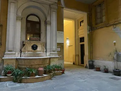 a fountain in the middle of a building with potted plants at Bed & Breakfast RCH Roman Central House in Rome