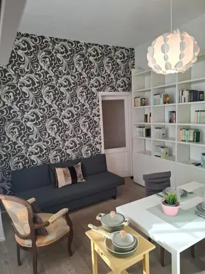 a living room with a blue couch and a patterned wall at Casetta Vaticano in Rome